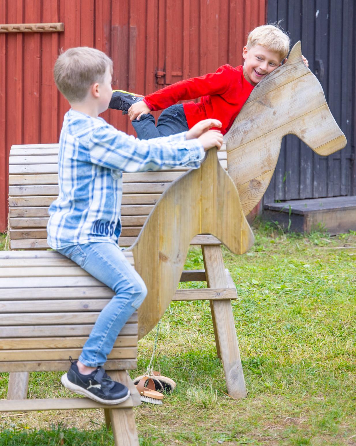 Barn leker med trähästarna